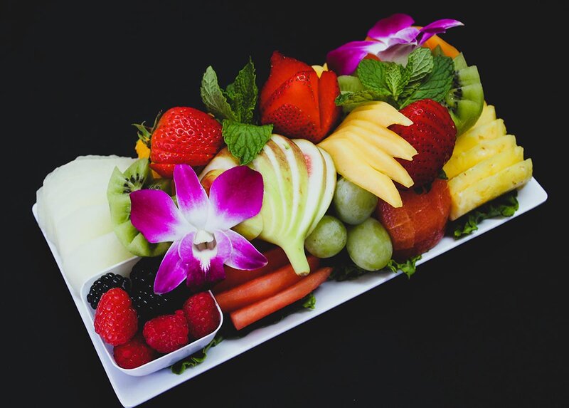 Fresh fruit platter with strawberries, melon, grapes, and kiwi