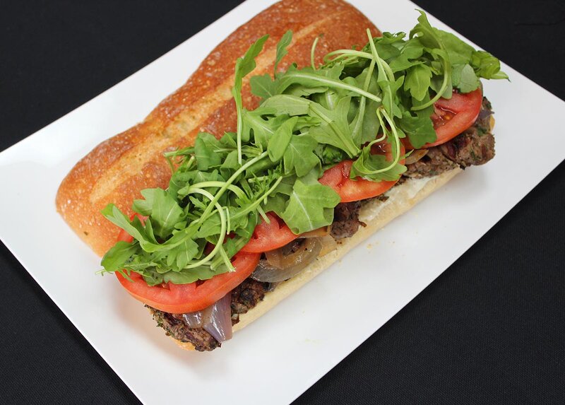 Sliced steak sandwich with sprouts and tomato